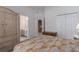Bedroom featuring a woven wardrobe and a view of the attached bathroom and entry way at 11458 30Th E Cv, Parrish, FL 34219