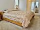 Comfortable bedroom with a plush bed, side table and a view of the connected bathroom at 11458 30Th E Cv, Parrish, FL 34219