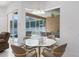 Bright dining area with glass table, screened lanai view, and access to the outdoor pool area at 11458 30Th E Cv, Parrish, FL 34219