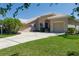 Beautiful single-story home with a well-manicured lawn, mature trees, and a long driveway leading to a three-car garage at 11458 30Th E Cv, Parrish, FL 34219
