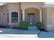 Close-up of the home's front entrance featuring columns and neatly manicured bushes and plants at 11458 30Th E Cv, Parrish, FL 34219