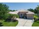 Charming single-story home with a well-manicured lawn, mature trees, and a long driveway leading to a two-car garage at 11458 30Th E Cv, Parrish, FL 34219