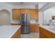 Kitchen features stainless steel appliances, wooden cabinets, and a center island with a white countertop at 11458 30Th E Cv, Parrish, FL 34219