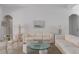 Comfortable living room with neutral tones, including an off-white couch and glass coffee table at 11458 30Th E Cv, Parrish, FL 34219