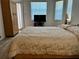 Cozy main bedroom features a comfortable bed, a wooden wardrobe, and natural light from the window at 11458 30Th E Cv, Parrish, FL 34219