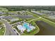 Aerial view of community pool with palm trees and lounge chairs surrounded by multiple ponds and residential homes at 11571 Little River Way, Parrish, FL 34219