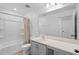 Bathroom features a tub with shower, granite counters, and gray cabinets at 11571 Little River Way, Parrish, FL 34219