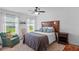 Cozy bedroom featuring a wooden headboard, ceiling fan, and natural light from two windows at 11571 Little River Way, Parrish, FL 34219