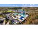 Aerial view of community pool, waterslide and lounge area with beautiful lake backdrop at 11571 Little River Way, Parrish, FL 34219