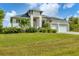 Well-maintained single-Gathering home with lush green lawn, mature landscaping, and attached two-car garage at 14322 Cando Ave, Port Charlotte, FL 33981