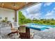 Outdoor living space featuring a covered patio, outdoor kitchen, swimming pool, and lush greenery for entertainment at 14322 Cando Ave, Port Charlotte, FL 33981