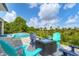 Relaxing pool area with outdoor seating, a fire pit, and tropical landscaping, ideal for leisure and entertainment at 14322 Cando Ave, Port Charlotte, FL 33981