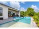Luxury outdoor pool and spa area with covered patio, summer kitchen, and landscaped backyard for outdoor enjoyment at 14322 Cando Ave, Port Charlotte, FL 33981