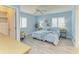 Light-filled bedroom with wood-look tile, plantation shutters, and ensuite bath at 148 N Blvd Of The Presidents, Sarasota, FL 34236
