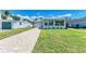 Charming single-story home with a paver driveway, lush green lawn, and a freshly painted light green exterior at 148 N Blvd Of The Presidents, Sarasota, FL 34236