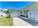 This home features a single-car garage and a paver driveway with mature landscaping at 148 N Blvd Of The Presidents, Sarasota, FL 34236