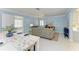 An open-concept living space features white floors and beachy decor at 148 N Blvd Of The Presidents, Sarasota, FL 34236