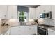 Bright kitchen featuring white cabinets, stainless steel appliances, and stylish backsplash at 16152 Isola Pl, Bradenton, FL 34211