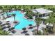 Aerial view of a luxurious, uniquely shaped pool with palm trees, sun loungers, and poolside bar, offering resort-style living at 16152 Isola Pl, Bradenton, FL 34211
