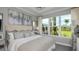 Calming main bedroom with tray ceiling, a large window providing ample natural light, and neutral decor at 16210 Isola Pl, Bradenton, FL 34211