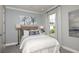 Comfortable bedroom with calm decor, a cozy bed with a woven headboard, and bright natural light at 16210 Isola Pl, Bradenton, FL 34211