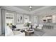 Bright living room with recessed lights, tray ceiling, neutral furniture, and view of the modern kitchen at 16210 Isola Pl, Bradenton, FL 34211