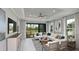 Bright and airy living room featuring stylish decor, a ceiling fan, and sliding glass doors to the outdoor patio at 16210 Isola Pl, Bradenton, FL 34211