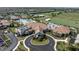 Aerial view of clubhouse with porte cochere, tile roof, and manicured landscaping at 17810 Gawthrop Dr # 406, Bradenton, FL 34211