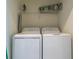 Convenient laundry room with modern washer and dryer units and wire shelf at 17810 Gawthrop Dr # 406, Bradenton, FL 34211