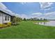 Expansive backyard featuring a tranquil pond view and lush green landscaping at 17827 Cherished Loop, Lakewood Ranch, FL 34211