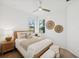 Cozy bedroom with natural wood furniture, soft bedding, and natural light at 17827 Cherished Loop, Lakewood Ranch, FL 34211
