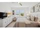 Tastefully decorated bedroom with pond view, dresser and luxurious bedding at 17827 Cherished Loop, Lakewood Ranch, FL 34211