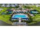 Beautiful aerial image of community pool, tennis courts, and clubhouse with lush landscaping and lake at 17827 Cherished Loop, Lakewood Ranch, FL 34211