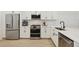 Contemporary kitchen features stainless steel appliances, white cabinets, and stone countertops at 17827 Cherished Loop, Lakewood Ranch, FL 34211