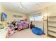 Bedroom featuring a ceiling fan and window, styled with a blue beanbag and a shelving unit at 1809 67Th W St, Bradenton, FL 34209
