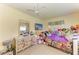Bedroom featuring a ceiling fan and window, styled with a dresser, television and toys at 1809 67Th W St, Bradenton, FL 34209