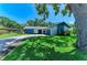 Well-maintained single-story home with attached garage and manicured lawn, enhanced by a mature shade tree at 1809 67Th W St, Bradenton, FL 34209