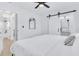 Bright bedroom with black ceiling fan, modern barn door, and view of bathroom at 1921 Fern Ave, Sarasota, FL 34235