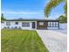 Well-maintained home with vibrant green lawn and freshly painted exterior and manicured landscaping at 1921 Fern Ave, Sarasota, FL 34235