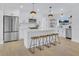 Modern white kitchen with stainless steel appliances, island, and wood bar stools at 1921 Fern Ave, Sarasota, FL 34235