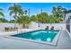 Refreshing pool area with lounge seating, palm trees, and white fence at 1921 Fern Ave, Sarasota, FL 34235