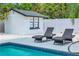 Poolside view with lounge chairs and a modern pool house, perfect for relaxation and outdoor enjoyment at 1921 Fern Ave, Sarasota, FL 34235