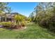 Backyard features manicured lawn and tropical landscaping at 19798 Cobblestone Cir, Venice, FL 34292