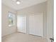 Spacious bedroom featuring two closets, tile floor, ceiling fan, and a sunlit window at 19798 Cobblestone Cir, Venice, FL 34292