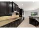 Modern kitchen with dark cabinets, granite countertops, and stainless steel appliances at 19798 Cobblestone Cir, Venice, FL 34292