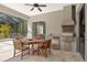 Covered patio has grill, stainless steel mini-fridge, and wooden dining set at 19798 Cobblestone Cir, Venice, FL 34292
