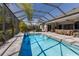 View of screened-in pool and spa and backyard seating area at 19798 Cobblestone Cir, Venice, FL 34292