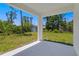 Covered back patio offering an outdoor living space with views of the backyard and green space at 2290 Beeville Ave, North Port, FL 34286