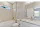 Modern bathroom with tiled shower over tub, granite counters, and ample lighting at 2290 Beeville Ave, North Port, FL 34286