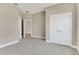 Light-filled bedroom with carpeted floors, neutral walls, and an open doorway to the bathroom at 2290 Beeville Ave, North Port, FL 34286